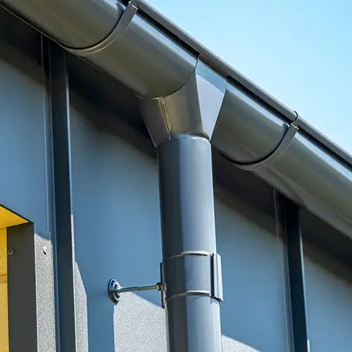 Водосточная система Optima серого цвета на свесе крыши