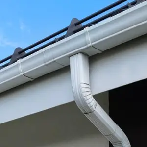 Водосточная система Vortex белого цвета на фоне белого фасада